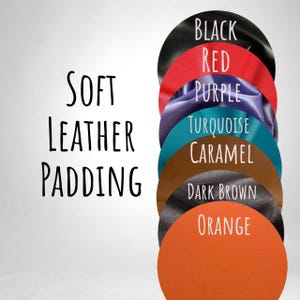 May include: A selection of leather swatches in various colours: black, red, purple, turquoise, caramel, dark brown, and orange. The text "SOFT LEATHER PADDING" is on the left, with colour names on the right.