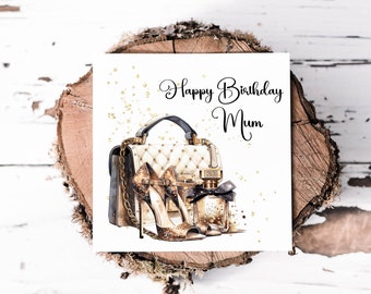 Op de afbeelding: Een witte kaart met gouden glitteraccenten en een zwart-witte illustratie van een handtas, een hoge hak en een parfumfles. De kaart zegt "Happy Birthday Mum".