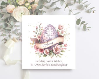 May include: A square Easter greeting card with a watercolour design. The card shows a decorated egg with a banner reading "Anna", surrounded by pink flowers and greenery. The text at the bottom reads "Sending Easter Wishes To A Wonderful Granddaughter".