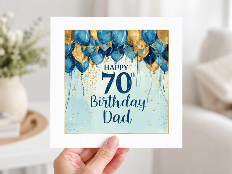 May include: A square greeting card featuring a festive design with blue and gold balloons at the top. The text reads Happy 70th Birthday Dad in dark blue lettering. The background is a light blue watercolor wash with gold confetti accents.