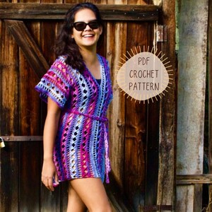 May include: A colorful, short-sleeved crochet dress in shades of purple, pink, and blue, with a matching belt. The dress features a V-neck and openwork design. The image includes the text "PDF Crochet Pattern".