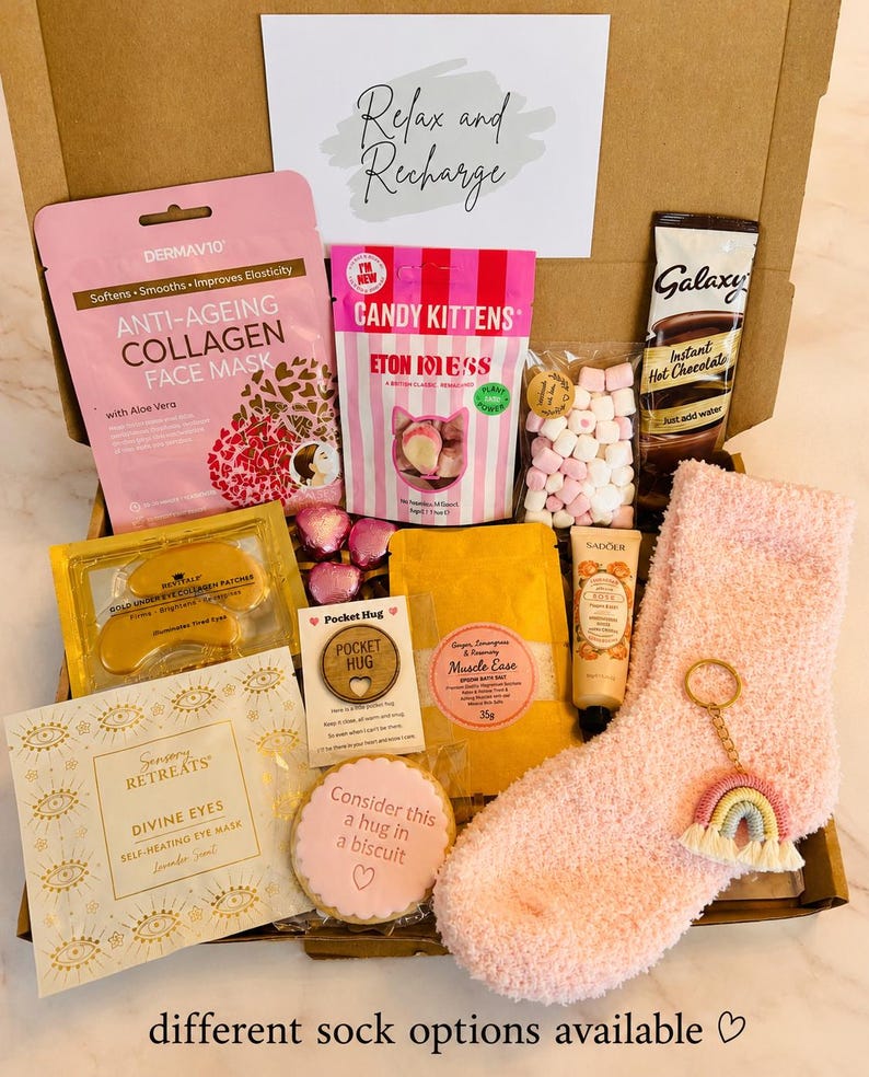 our hug in a box - includes pick cosy socks, hug biscuit, candy kitten sweets, hug token, rainbow keyring, self heating eye mask, gold collagen under eye masks, face sheet mask, hot chocolate sachet, mini marshmallows, bath salts, Handcream….ready to shit direct to the recipient