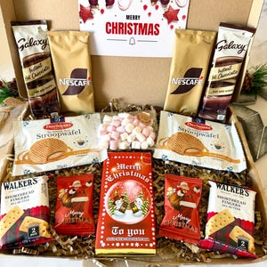 May include: A cardboard gift box containing two Galaxy instant hot chocolate packets, two Nescafe coffee sachets, two Daelmans stroopwafel packages, two Walker's shortbread finger packs, two Santa-themed chocolate bags, and a Merry Christmas chocolate bar.