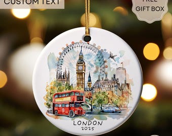 May include: A round, white ceramic ornament with a watercolor illustration of London landmarks, including the London Eye, Big Ben, and a red double-decker bus. The text "LONDON 2025" is below the image. The ornament has a gold string for hanging.