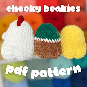 May include: Three crocheted egg-shaped items in white, green and brown, and yellow. The white egg has a red comb. The green and brown egg has a white zig-zag trim. The text "cheeky beakies" and "pdf pattern" are in white.
