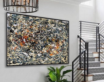 May include: Abstract art print with black, white, yellow, orange, and blue paint splatters on a beige background. The print is framed in black and hanging on a white wall.