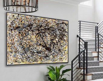 May include: Abstract art painting with black, white, and yellow paint splatters on a canvas. The painting is framed in black and hanging on a white wall.