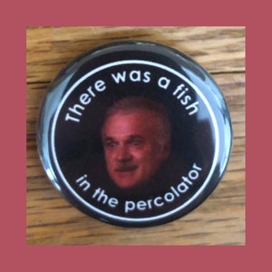 May include: A black and white button with a picture of a man's face and the text "There was a fish in the percolator".
