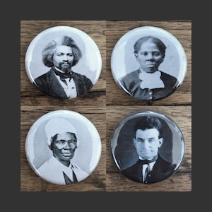 May include: Four black and white button badges featuring historical figures. The badges are circular and have a white background. The figures are all in black and white and are wearing clothing from the 19th century.