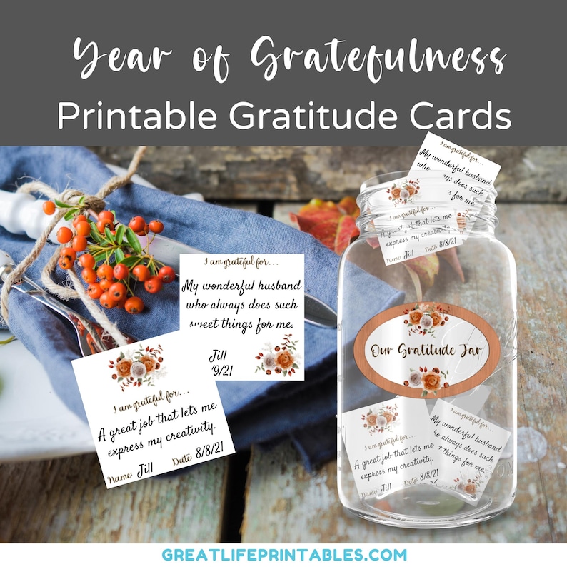 Może przedstawiać: Szklany słoik z brązową etykietą z napisem "Our Gratitude Jar". Słoik jest wypełniony małymi kartkami z ręcznie napisanymi wiadomościami wdzięczności. Kartki mają kwiatowy wz&oacute;r w kolorze pomarańczowym, białym i brązowym. Kartki leżą na drewnianym stole z niebieskim serwetką i talerzem z czerwonymi jagodami.