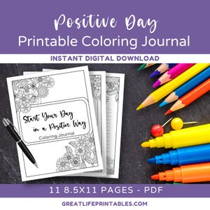 May include: A printable coloring journal with the title "Positive Day Printable Coloring Journal" and the text "Start Your Day in a Positive Way Coloring Journal". The journal has 11 pages and is 8.5 inches by 11 inches. The image shows the journal cover with a floral design and a pen and markers on a dark gray surface.