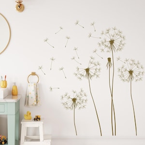 May include: A white wall with a brown dandelion wall decal. The decal features multiple dandelions with seeds blowing in the wind.