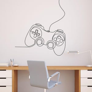 Könnte beinhalten: Eine Schwarzweiß-Zeichnung eines Videospiel-Controllers an einer weißen Wand. Der Controller ist mit einem Kabel verbunden, das in einer geschwungenen Linie gezeichnet ist. Der Controller befindet sich in der Mitte des Bildes und ist der Hauptfokus.
