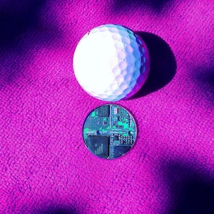 Recycled circuit board set in a round Stainless Steel bezel with laser engraved personalisation. To use as a golf ball marker, game token, decision coin.