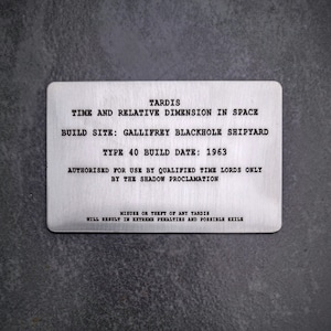 May include: A silver metal plaque with black text that reads "TARDIS Time and Relative Dimension in Space Build Site: Gallifrey Blackhole Shipyard Type 40 Build Date: 1963 Authorised for use by qualified Time Lords only by the Shadow Proclamation Misuse or theft of any TARDIS will result in extreme penalties and possible exile."