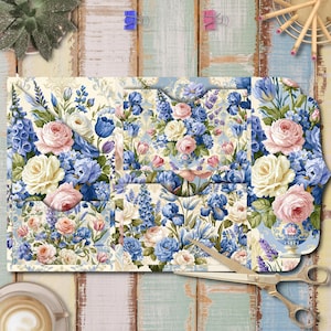 May include: A multi-pocketed paper organizer featuring a floral pattern with pink roses, blue irises, and lavender sprigs on a cream background. The organizer has several slots for documents and is displayed with a pair of gold-toned metal scissors.