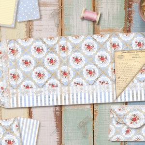 May include: A blue and white patterned paper envelope with a gold trim and a floral design. The envelope is open and a letter is visible inside. The letter is written in cursive and has a blue and white patterned border. The envelope is on a wooden surface with a cup of coffee and a spool of thread.