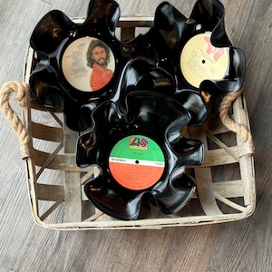 May include: Three black vinyl record bowls in a woven basket. The bowls are shaped like flower petals. The records have labels with different album art and text, including "Atlantic" and "Stereo".