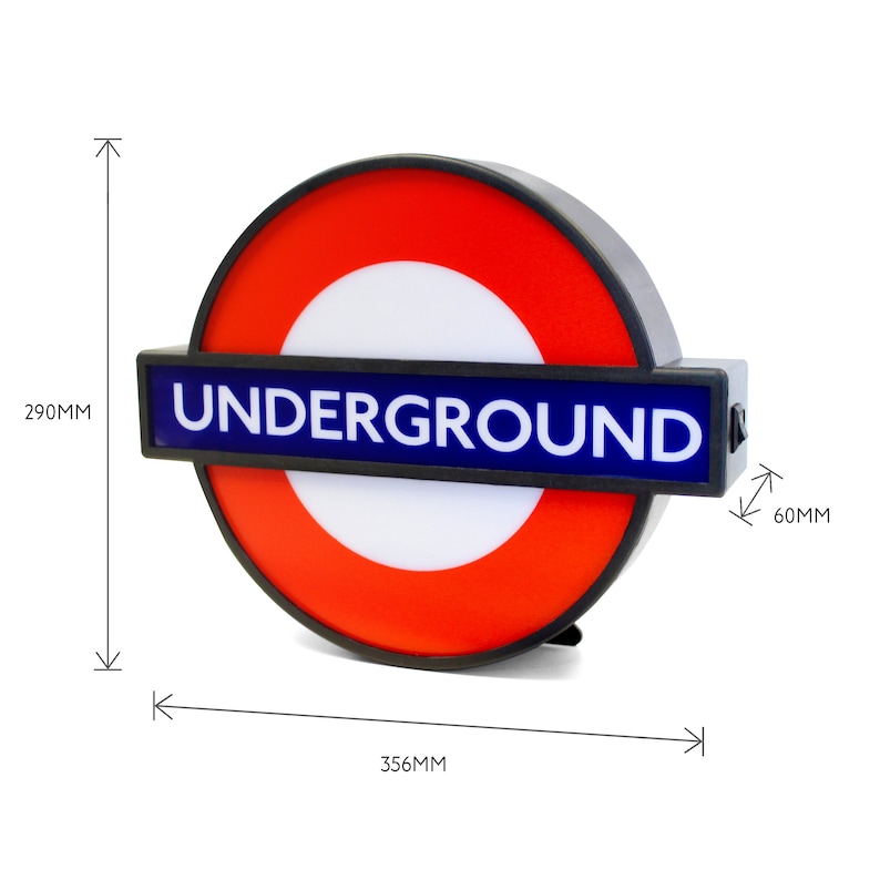 Peut inclure: Un panneau noir et rouge du m&eacute;tro londonien avec le mot "UNDERGROUND" en lettres bleues. Le panneau mesure 356 mm de large et 290 mm de haut.