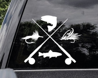 May include: A white vinyl decal applied to a vehicle window featuring a graphic design of two crossed fishing rods. The design includes silhouettes of two fish and two fishing flies positioned between the rods in a symmetrical arrangement.