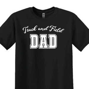 Może przedstawiać: Czarny T-shirt z białym tekstem, kt&oacute;ry brzmi "Track and Field Dad" w sportowym kroju.