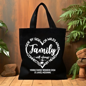 May include: Black canvas tote bag with white text that reads "Side by side or miles apart, Family will always be connected by heart."  The bag also has the text "Young Family Reunion 2024, St. Louis, Missouri."