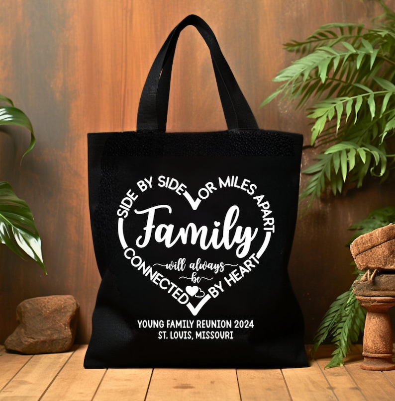 May include: Black canvas tote bag with white text that reads "Side by side or miles apart, Family will always be connected by heart."  The bag also has the text "Young Family Reunion 2024, St. Louis, Missouri."