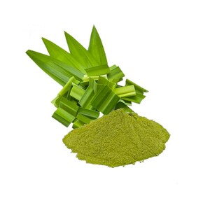 May include: A pile of fine, light green pandan powder positioned in front of a cluster of fresh, vibrant green pandan leaves. The leaves are long, pointed, and folded, while the powder has a soft, granular texture and a consistent color.