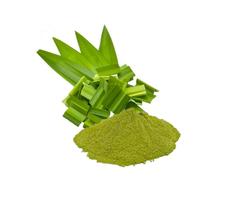 May include: A pile of fine, light green pandan powder positioned in front of a cluster of fresh, vibrant green pandan leaves. The leaves are long, pointed, and folded, while the powder has a soft, granular texture and a consistent color.