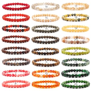 Könnte beinhalten: Vierundzwanzig verschiedene Edelstein-Armbänder, jedes mit einer einzigartigen Farbe und einem einzigartigen Muster. Die Armbänder sind von 1 bis 24 nummeriert.