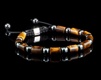May include: A brown and black beaded bracelet with a silver clasp. The bracelet is made with tiger's eye and hematite beads.