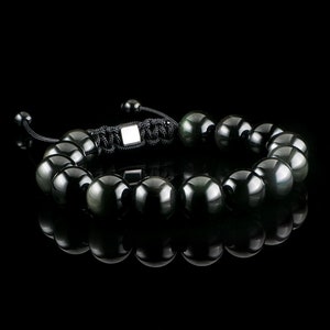 May include: A black beaded bracelet with a silver clasp and black cord. The beads are round and have a glossy finish.