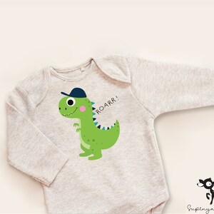 K&ouml;nnte beinhalten: Ein grauer lang&auml;rmeliger Baby-Strampler mit einem gr&uuml;nen Dinosaurier, der eine blaue Baseballkappe tr&auml;gt. Der Dinosaurier l&auml;chelt und sagt "ROARR!"