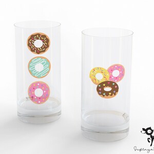 May include: Two clear glass tumblers with donut designs. One tumbler has three donuts stacked vertically, one with chocolate frosting and sprinkles, one with blue frosting and white drizzle, and one with pink frosting and sprinkles. The other tumbler has three donuts arranged in a triangle, one with yellow frosting and sprinkles, one with pink frosting and sprinkles, and one with chocolate frosting and sprinkles.