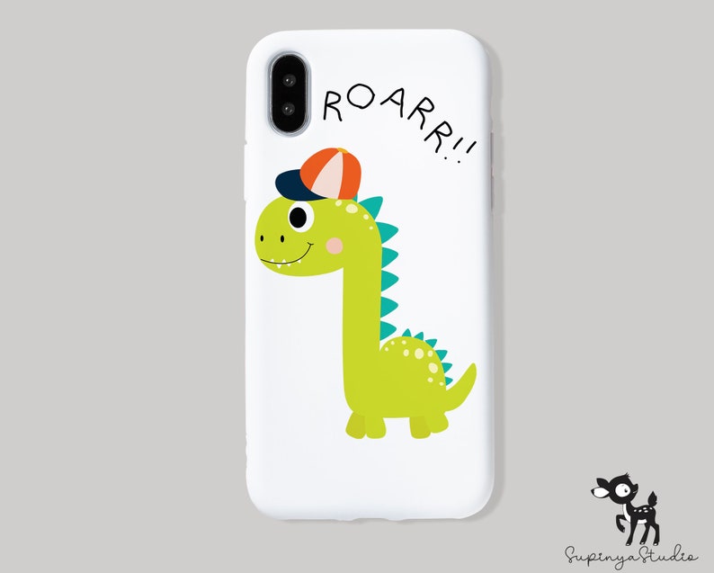 K&ouml;nnte beinhalten: Weisse Handyh&uuml;lle mit einem gr&uuml;nen Dinosaurier, der eine rot-orange Baseballkappe tr&auml;gt. Der Dinosaurier l&auml;chelt und sagt "ROARR!!" in schwarzer Schrift.