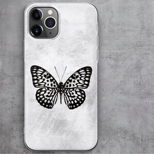 May include: A white phone case with a black and white butterfly design. The case has a textured surface and a clear back.