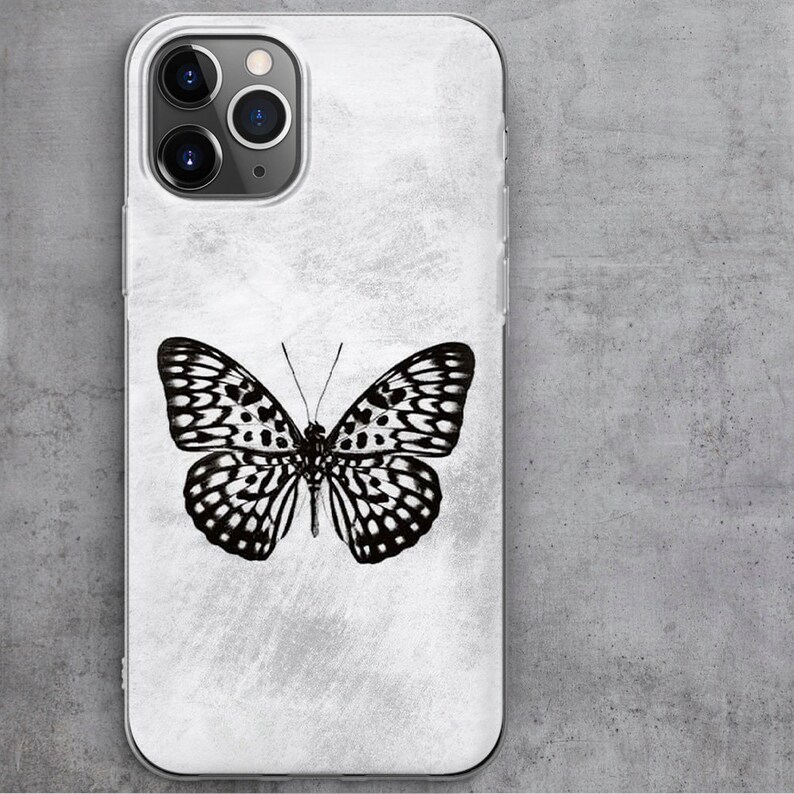 May include: A white phone case with a black and white butterfly design. The case has a textured surface and a clear back.
