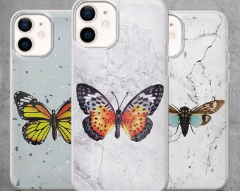 May include: Three phone cases with butterfly and insect designs. The first case has a yellow and black butterfly on a light gray background with silver flecks. The second case features an orange and black butterfly on a white marble background. The third case has a brown and blue insect on a white marble background.