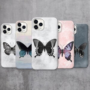May include: Five different phone cases with butterfly designs. The cases are all white with a different butterfly design on each. The butterflies are all black and white, with the exception of one which is purple and white.
