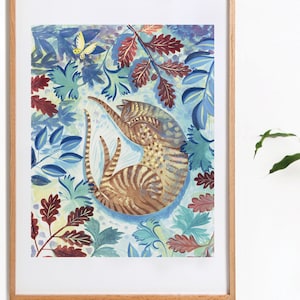 Puede incluir: Una ilustración enmarcada de un gato acurrucado en una cama de hojas azules, verdes y rojas. Una mariposa amarilla vuela sobre el gato.