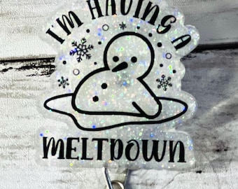 May include: A white glitter badge holder with a snowman melting and the text "I'm having a meltdown".