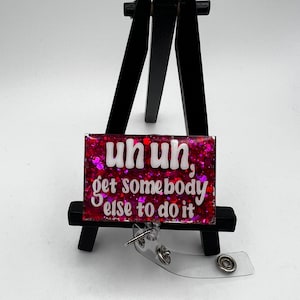 May include: Pink glitter badge holder with a white background and the text "uh uh, get somebody else to do it".