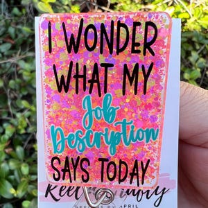 May include: Pink glitter badge holder with the text "I wonder what my job description says today".