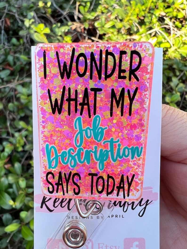 May include: Pink glitter badge holder with the text "I wonder what my job description says today".