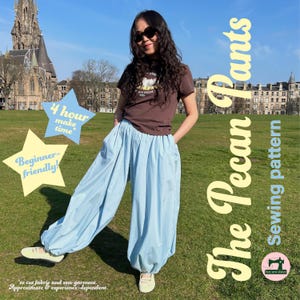May include: A brown short-sleeved t-shirt and light blue loose-fitting pants with elasticated ankles. Text on the image reads: The Pecan Pants Sewing pattern, 4 hour make time, and Beginner friendly. The garment is shown in a park setting.