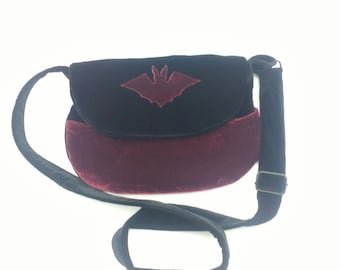 Mittlere Samttasche in schwarz und bordeaux, mit Fledermaus-Applikation und praktischer Beuteltasche vorn. 26 x 18 cm