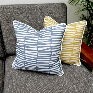 Geometrische Streifen Dekokissen mit Kontrastfarbige Paspel in Senfgelb/Ocker/Blau, 100% Baumwolle von Ashley Wilde.