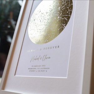 May include: A framed star map print featuring a circular gold foil constellation design on a white background. The text reads ALWAYS & FOREVER, Michael & Olivia, 14 FEBRUARY 2021, MELBOURNE, VIC AUSTRALIA, and the coordinates 37.8136&deg; S, 144.9631&deg; E.
