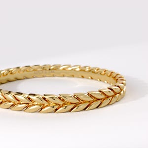 May include: A polished 14k yellow gold ring featuring a continuous, repeating leaf or wheat pattern around the entire band. The interior of the band is clearly engraved with the text LUCY'S 14K, indicating the metal purity and brand name.