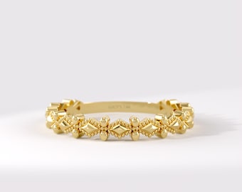 May include: A yellow gold ring featuring a repeating pattern of small diamond-shaped elements and tiny spherical beads along the entire band. The interior of the band is clearly engraved with the text LUCY'S 14K, indicating the metal purity.